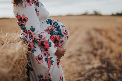 Midsection of woman standing on field