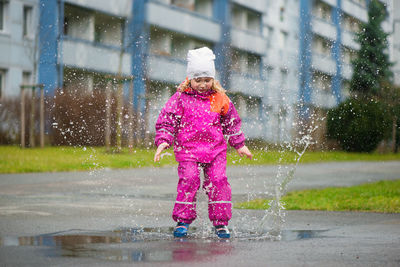 Full length of girl standing on wet rainy season