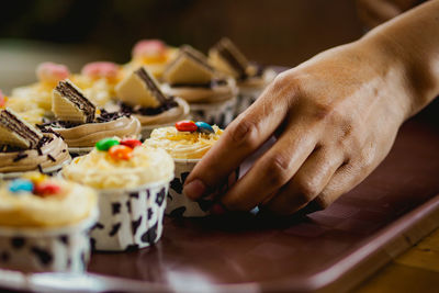 Cropped hand of person preparing food on table