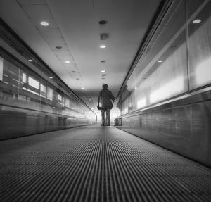 Rear view of woman on illuminated corridor