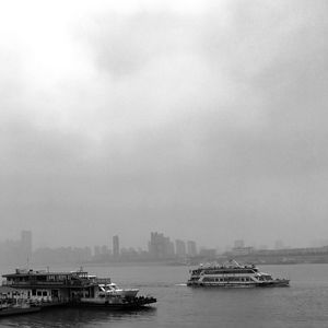 Boat sailing on sea against sky in city