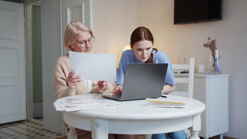 Young woman using laptop at home