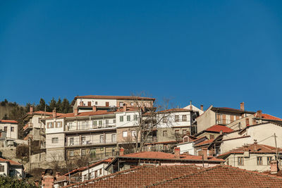 Buildings in city against clear blue sky