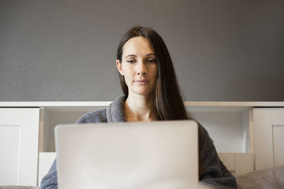 Businesswoman using laptop at home