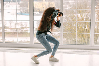 A beautiful african-american photographer girl with a camera. photo shoot in the studio.