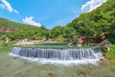 Scenic view of waterfall against mountain