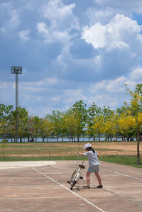 A girl try to ride the bicycle on a sunny day 