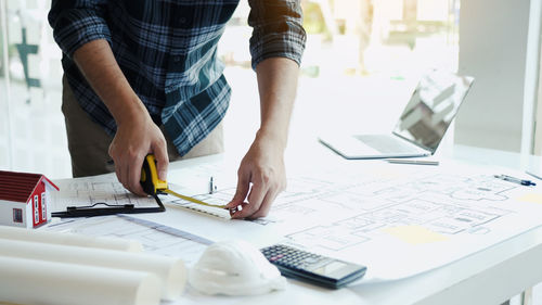 Low section of man working on table