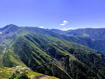 Scenic view of mountains against blue sky