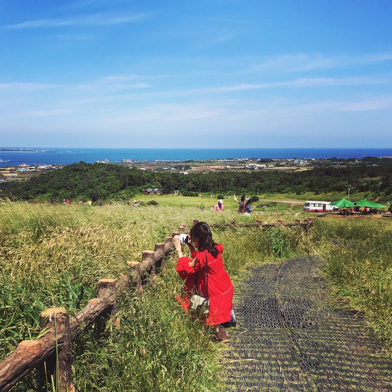 horizon over water, sea, sky, grass, tranquil scene, tranquility, scenics, person, leisure activity, beauty in nature, lifestyles, men, beach, nature, water, cloud - sky, relaxation, cloud, sitting