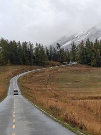 Road amidst field against sky