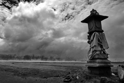 Statue by water against sky