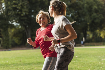 Granddaughter and grandmother having fun, jogging together in the park