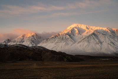 Scenic view of snowcapped mountains against sky during sunset