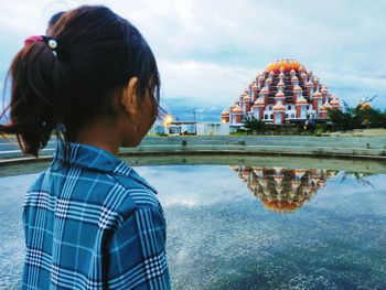 Rear view of woman standing against sky