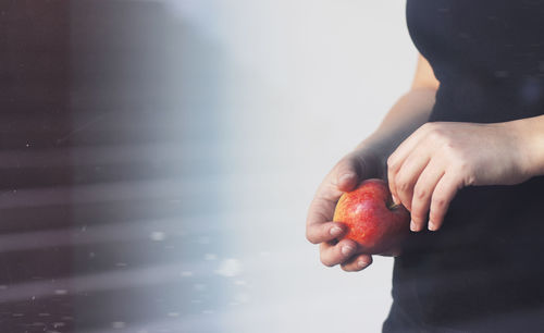 Close-up of hand holding apple against blurred background