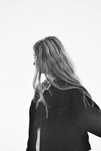 Woman with long hair standing against white background