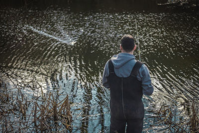 Rear view of boy standing in water