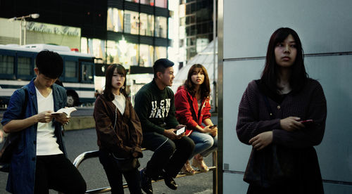 Young couple sitting in front of people