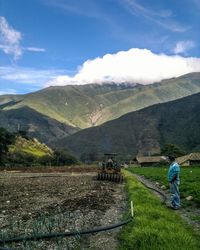 Man working on agricultural field against sky