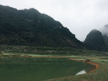 Scenic view of lake and mountains against sky
