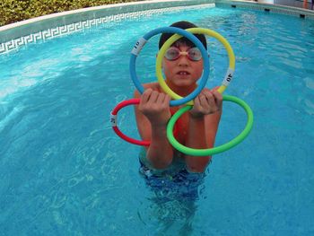 Boy playing in the swimming pool with rings