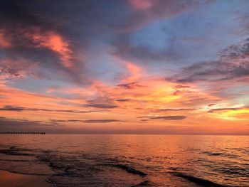 Scenic view of sea against dramatic sky during sunset