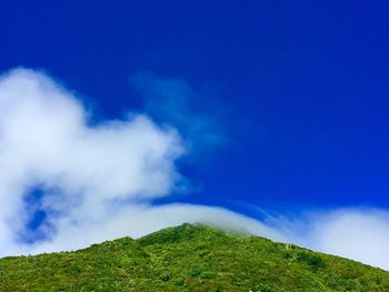 Scenic view of green landscape against blue sky