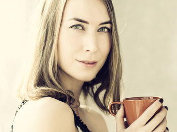 Portrait of beautiful young woman drinking coffee