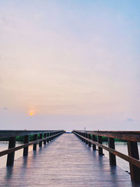 Pier over sea against sky during sunset