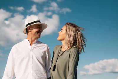 Man and woman wearing mask against sky