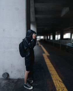 Full length of young man photographing in parking lot