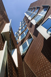 Low angle view of modern office building against sky