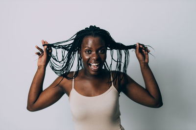 Portrait of happy young woman against gray background