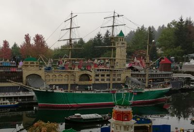 Boats moored at harbor against sky