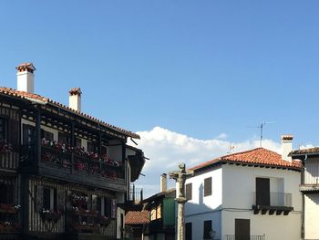 Low angle view of village buildings against blue sky