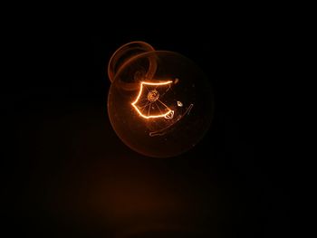 Close-up of light bulb against black background