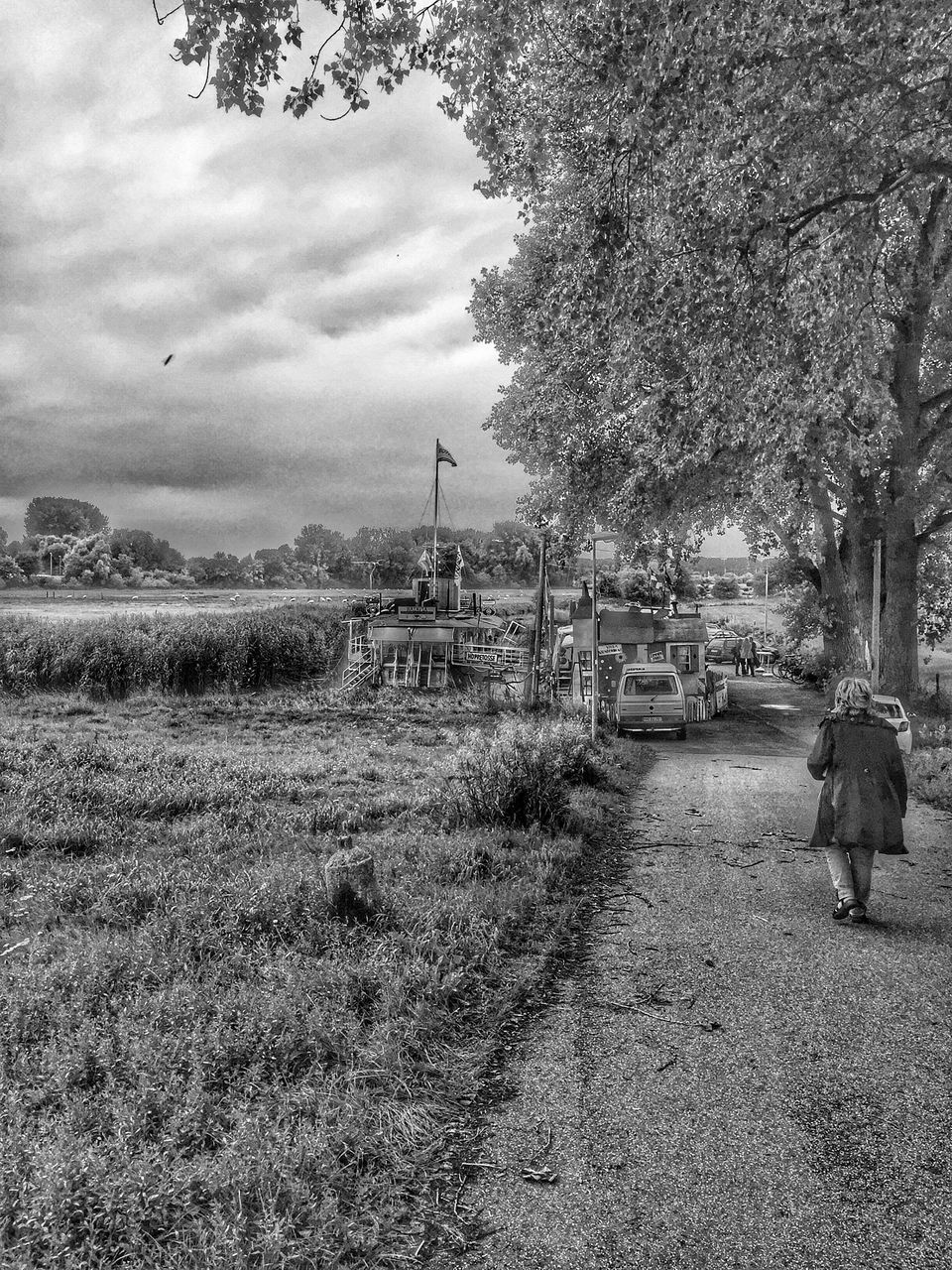 MAN CYCLING ON FIELD AGAINST SKY