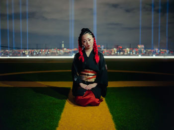 Portrait of woman kneeling in stadium