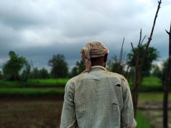 Rear view of a man standing on field