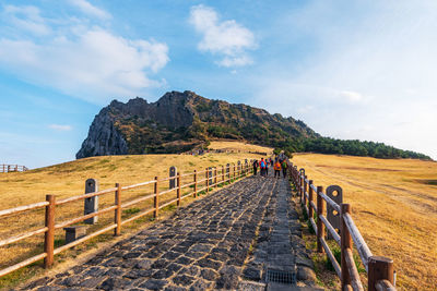 People on mountain road against sky