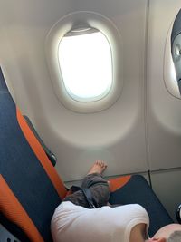 High angle view of boy relaxing on airplane seat