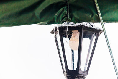 Low angle view of electric lamp hanging on wall