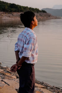 Side view of young woman standing at beach