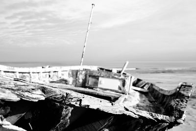 Boat moored on beach against sky