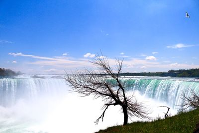 Scenic view of niagra falls against cloudy sky