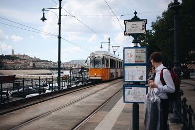 Train at railroad station in city against sky