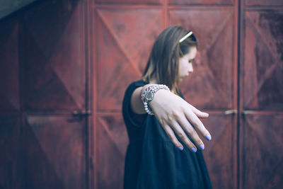 Close-up of young woman showing fingernails with nail polish