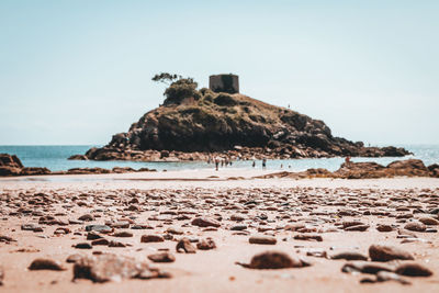 Rocks on beach against clear sky