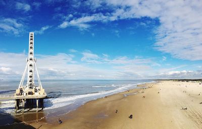 Ferris wheel at beach against sky in scheveningen